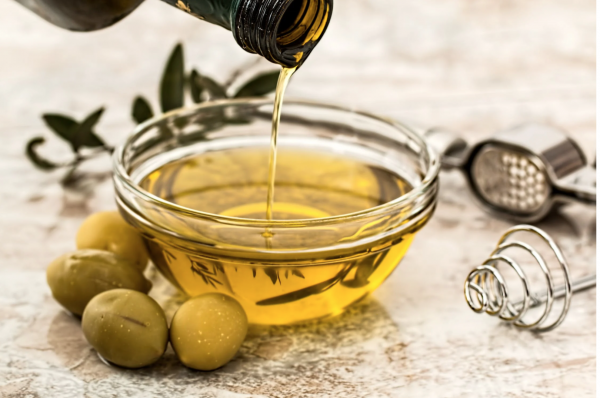 Olio dorato che viene versato in una ciotola di vetro, simbolo di purezza e naturalità, rappresenta l'eccellenza degli oli naturali come l'Olio di CBN® Special Gold CBD Full Spectrum® per il benessere quotidiano.